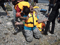 Syrian refugees react as they arrive after crossing aboard a dinghy from Turkey