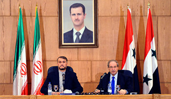 Iran's Deputy Foreign Minister Hossein Amir Abdollahian, left, sits next to his Syrian counterpart Faisal Mekdad, right, during a joint press conference, in Damascus, Syria, Thursday, Sept. 3, 2015
