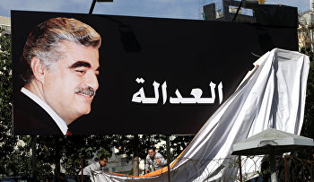 Supporters of slain former Lebanese Prime Minister Rafik Hariri, uncover a giant billboard with his portrait and Arabic that reads, "Justice"
