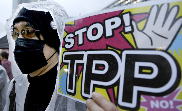 A protester holds a placard during a rally against the Trans-Pacific Partnership (TPP)