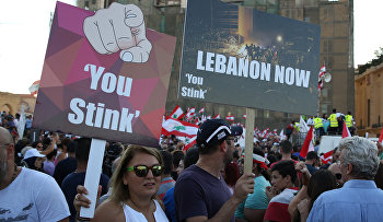 Lebanese anti-government protesters hold placards during a demonstration in Martyrs' Square, downtown Beirut, Lebanon
