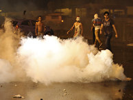 Lebanese anti-government protesters stand by tear gas during a protest against the ongoing trash crisis and government corruption, in downtown Beirut, Lebanon
