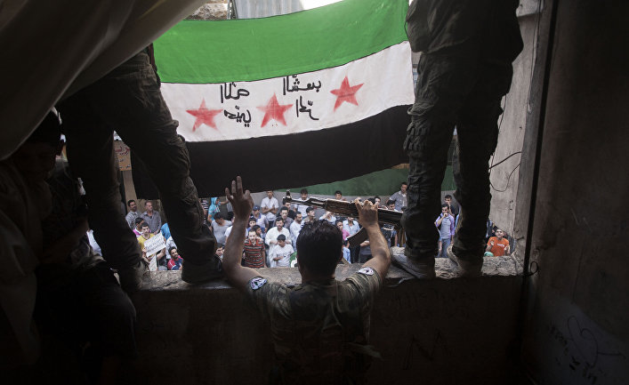 Free Syrian Army rebels hold a revolutionary flag during a demonstration in the Bustan al-Qasr neighborhood of Aleppo, Syria