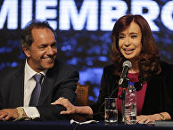Argentina's President Cristina Fernandez, right, laughs as she holds the arm of ruling party presidential candidate Daniel Scioli