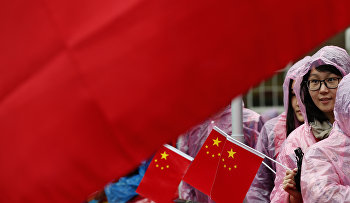 Supporters of Chinese President Xi Jinping hold up a large national flag of China