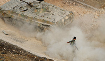A Syrian APC moves raising dust in Harasta, northeast of Damascus, Syria