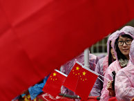 Supporters of Chinese President Xi Jinping hold up a large national flag of China