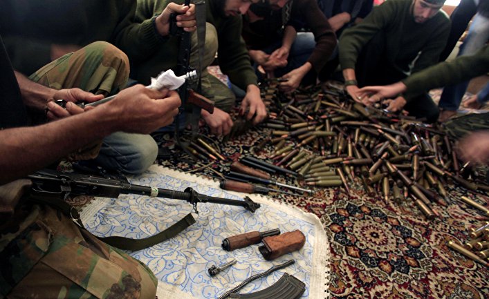 Free Syrian Army fighters clean their weapons and check ammunition