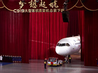 Chinese workers wave as a truck pulls out the first twin-engine 158-seater C919 passenger plane made by The Commercial Aircraft Corp. of China (COMAC)