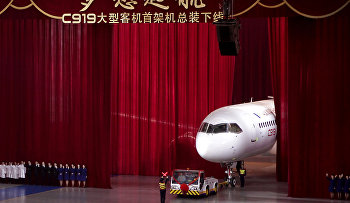 Chinese workers wave as a truck pulls out the first twin-engine 158-seater C919 passenger plane made by The Commercial Aircraft Corp. of China (COMAC)