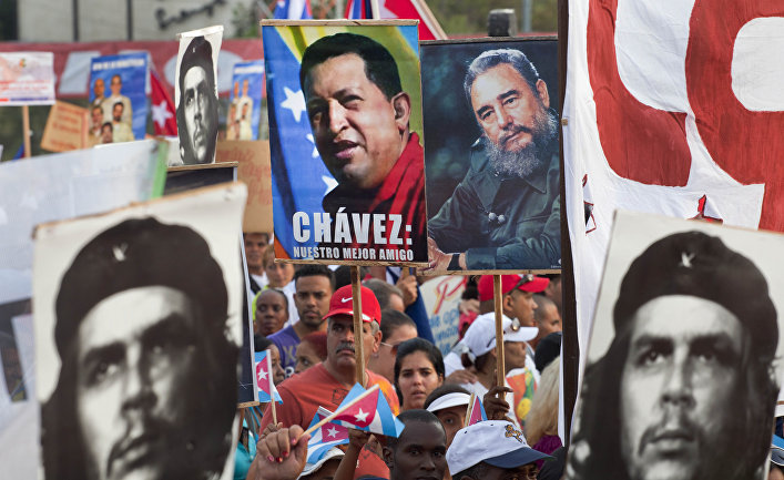 People hold up images showing Fidel Castro, second from right, Venezuela's late President Hugo Chavez