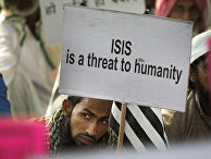 An Indian Muslim man holds a banner during a protest against ISIS