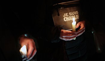 People hold candles and a placard reading "I am Charlie" as they gather to commemorate the victims of a terror attack against French satirical newspaper Charlie Hebdo in Paris