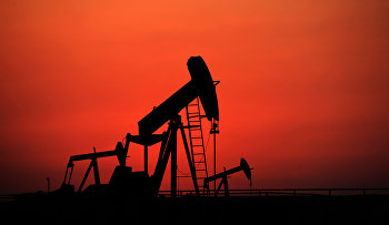 Oil pumps work at sunset  in the desert oil fields of Sakhir, Bahrain