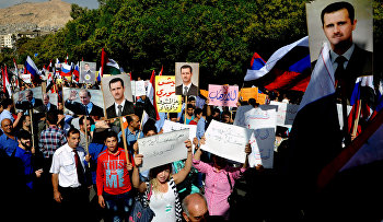Syrians holding photos of Syrian President Bashar Assad and Russian President Vladimir Putin, during a protest to thank Moscow for its intervention in Syria