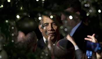 President Barack Obama is seen through holiday tree lights as he greets people in the audience during the second of two Hanukkah receptions the East Room of the White House in Washington