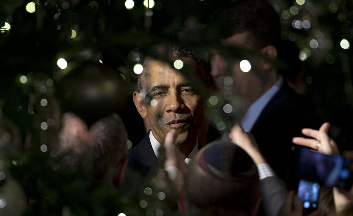 President Barack Obama is seen through holiday tree lights as he greets people in the audience during the second of two Hanukkah receptions the East Room of the White House in Washington