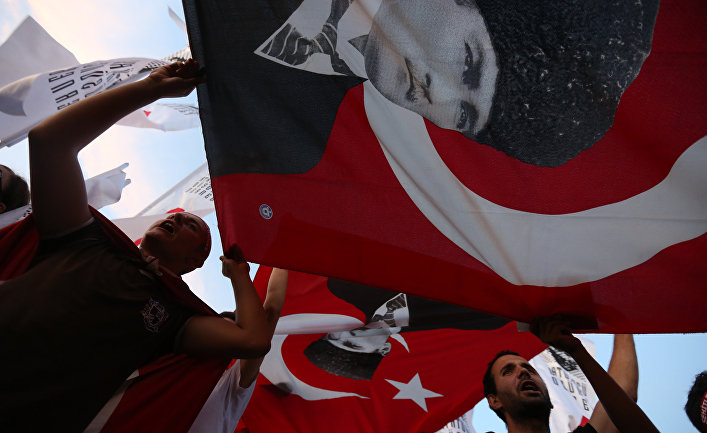 Men wave national flags with depictions of Turkey's founder Kemal Ataturk as they march to protest against the deadly attacks on Turkish troops, in Izmir, Turkey