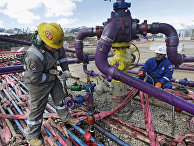 Workers tend to a well head during a hydraulic fracturing operation outside Rifle, in western Colorado.