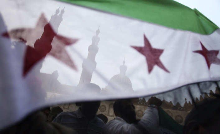 Protesters wave the Syrian revolution flag during a rally after the Friday prayer at Al-Azhar mosque in Cairo, Egypt.