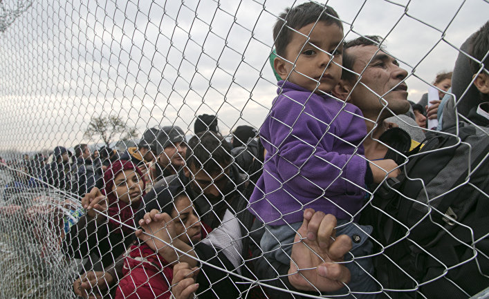 Stranded migrants, await entry into Macedonia on the Greek side of the border photographed through a fence from Macedonian side of the border, near the southern Macedonian town of Gevgelija