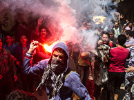 An Egyptian youth carries a lit flare as supporters of the Muslim Brotherhood gather in the El-Mataria neighborhood of Cairo, Egypt