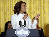First lady Michelle Obama pretends to dance to music as she arrives to speak in the East Room of the White House in Washington, Friday, Nov. 8, 2013